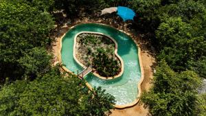 an aerial view of a pool in the middle of a park at Spazi Ha Glamping & Cenote in Yalcobá