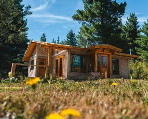a tiny house in a field with flowers at Cabure in Epuyén +5 photos