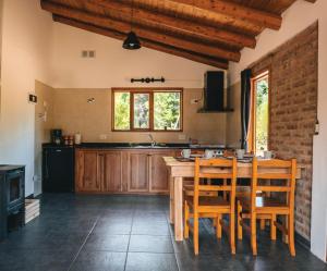 a kitchen with a wooden table and wooden chairs at Cabure in Epuyén