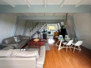 a living room with a couch and a table at Aroha A-Frames - Bush & Beach Retro Retreat in Coromandel Town +100 photos