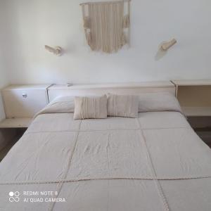 a white bed with two pillows on top of it at El buho in Roldán