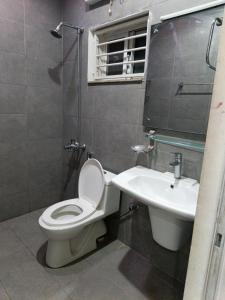 ein Badezimmer mit Toilette und Waschbecken in der Unterkunft IsLodge in Islamabad