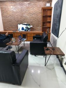 ein Zimmer mit Stühlen, einem Tisch und einem Fernseher in der Unterkunft IsLodge in Islamabad