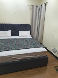 ein Bett in einem Zimmer mit Fenster in der Unterkunft IsLodge in Islamabad