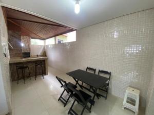 a dining room with a black table and chairs at Duplex 3 quartos 5 min da UFV in Viçosa