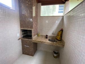 a tiled bathroom with a sink and a window at Duplex 3 quartos 5 min da UFV in Viçosa +5 photos