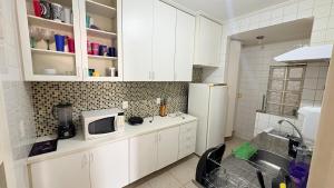 a kitchen with white cabinets and a white refrigerator at Duplex 3 quartos 5 min da UFV in Viçosa
