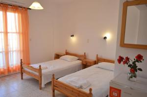 1 dormitorio con 2 camas y un jarrón de flores en Koukos en Agia Theodoti