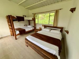 a bedroom with two bunk beds and a window at La Granja De Bam Bam in Sasaima +28 photos