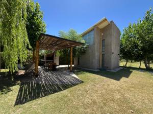 a house with a wooden deck in the yard at Alamos de Perdriel in Perdriel