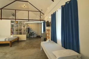 a room with two beds and blue curtains at YAMA APARTMENTS - Private Beachfront in General Luna