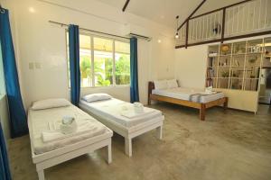 a room with two beds and a bench in it at YAMA APARTMENTS - Private Beachfront in General Luna
