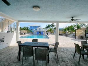 a patio with a table and chairs and a swimming pool at Marina View Cottage at Key Largo in Key Largo