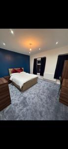 a bedroom with a large bed and a blue wall at Mayford Shared House in Manchester