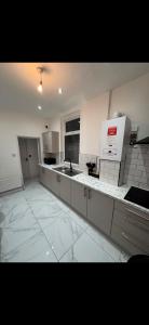 a large white kitchen with a sink and a counter at Mayford Shared House in Manchester +39 photos
