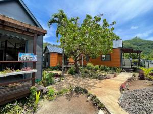 a garden in front of a house with a tree at Matira Tiny House 2 in Bora Bora