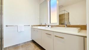 a white bathroom with a sink and a mirror at Lyra 2026 Home by GoodLive in Beveridge +41 photos