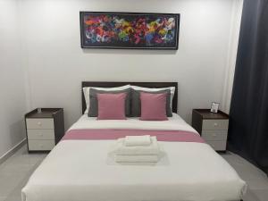 a bedroom with a large white bed with pink pillows at Viva La Rosa Hometel in Anda