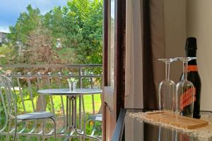 a balcony with a table and a wine bottle and a window at SUVAJ Rooms in Galatro