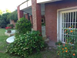 a front door of a brick house with flowers at El buho in Roldán