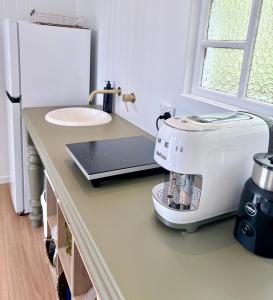 a kitchen counter with a mixer and a sink at Moana bungalow in Hideaway Bay