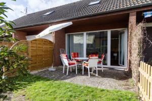 a patio with a table and chairs and an umbrella at Ferienwohnung-Mour in Dahme