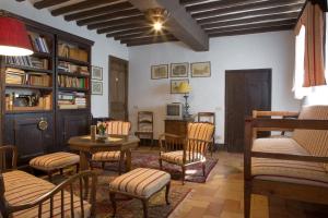 ein Wohnzimmer mit Stühlen, einem Tisch und einem Bücherregal in der Unterkunft Villa Pandolfi Elmi in Spello