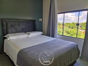 a bedroom with a bed with a large window at Residencia SG - Casa Duplex in Encarnación