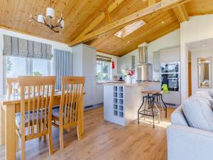 a kitchen and living room with a table and chairs at Nanny Goat Lodge in Crossway Green +19 photos