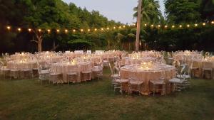 a group of tables with white chairs and lights at Hotel Delfin Playa Bejuco in Esterillos Este