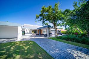 a house with a driveway and a tree at Luxury villa with Private beach access in Sosúa +94 photos