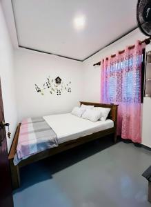 a bedroom with a bed and a window at Windy Oasis in Hikkaduwa