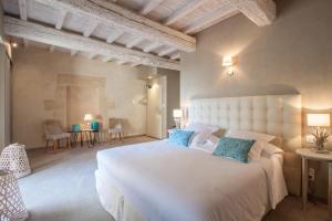 a bedroom with a large white bed with blue pillows at Boutique Hôtel La Villa MONTESQUIEU in Laudun