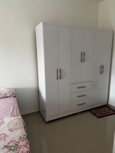 a bedroom with white cabinets and a bed at Loft reserva do Sahy- condado in Mangaratiba +1 photo