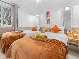 two beds with orange and white sheets in a room at Churchill Apartment- 4 Beds- Free Parking- Near NEC BHX & HS2 in Coleshill