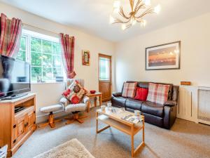 a living room with a couch and a tv at Halls Bank Farm in Plumbland
