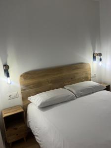 a bedroom with a white bed with a wooden headboard at Apartamento acogedor frente a Plaza del Cedro in Valencia