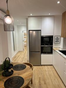 a kitchen with a table and a refrigerator at Apartamento acogedor frente a Plaza del Cedro in Valencia