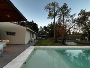 a swimming pool in a yard next to a house at Casa con pileta Funes in Funes