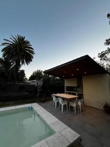 a patio with a table and chairs next to a pool at Casa con pileta Funes in Funes