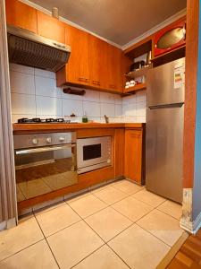 a kitchen with wooden cabinets and a stainless steel refrigerator at Deptos En Centro De Santiago in Santiago