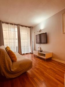 a living room with a couch and a television at Deptos En Centro De Santiago in Santiago
