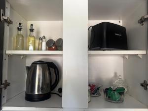 a coffee pot and a microwave on a shelf in a kitchen at Koocoland- Xumuc in Tupungato