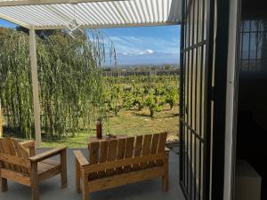 a patio with two benches and a view of a vineyard at Koocoland- Xumuc in Tupungato