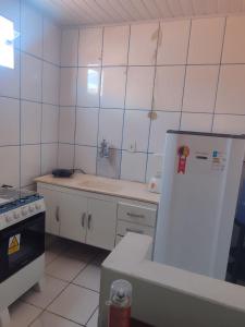 a white kitchen with a refrigerator and a stove at Casa c 3 Suítes 4 banheiros 4 quartos climatizados a passos da Praia, Centro e comércios in Alcobaça +14 photos
