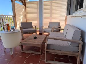 a porch with two chairs and a coffee table at Caribbean Lotus in Le François