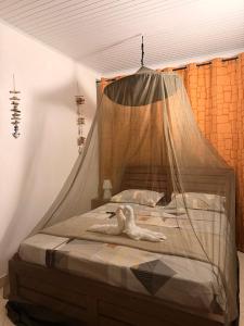 a bedroom with a bed with a mosquito net at Caribbean Lotus in Le François