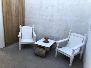 two white chairs and a table with a potted plant at Espacio Marea in Puerto Madryn