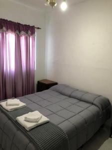 a bedroom with a bed with two towels on it at Espacio Marea in Puerto Madryn