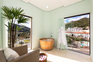 a bathroom with a tub and a large window at Hotel Guarany in Águas de Lindoia